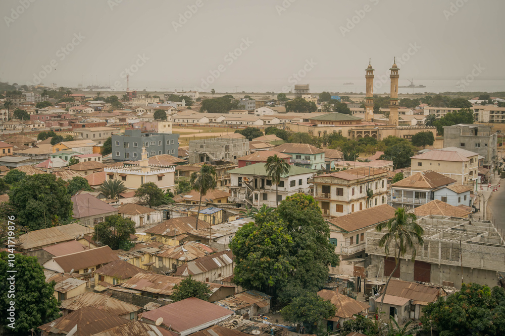 Obraz premium The scenic panorama view of Banjul city, a capital of Gambia, with mosque minaret, sea coast and roofs of African buildings. 