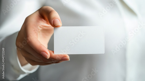 Woman holding a blank business card close-up. Mockup with free copy space.