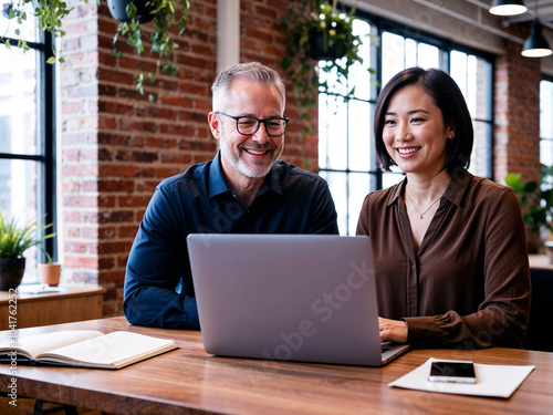 Happy Business Professionals Working Together on Laptop in a Modern Industrial Office