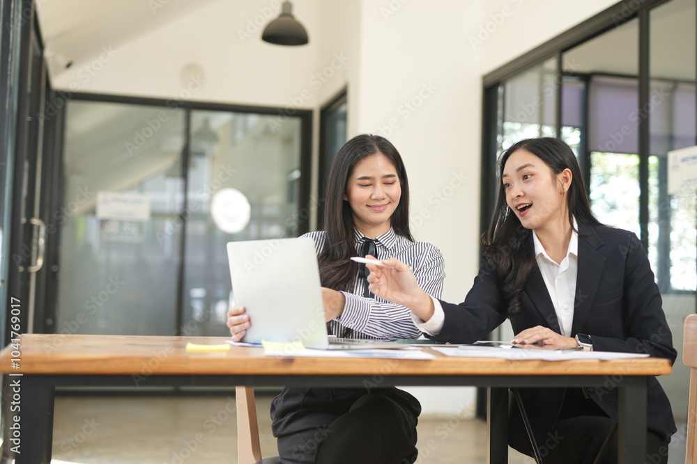 Happy Asian business people working together using laptop and tablet in office. Happy Asian business people working together using laptop and tablet in office.