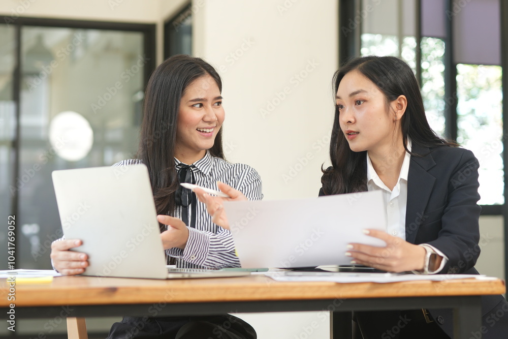 Happy Asian business people working together using laptop and tablet in office. Happy Asian business people working together using laptop and tablet in office.