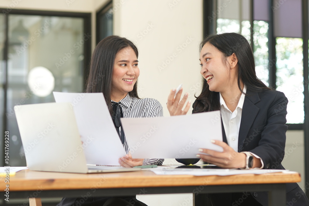 Happy Asian business people working together using laptop and tablet in office. Happy Asian business people working together using laptop and tablet in office.