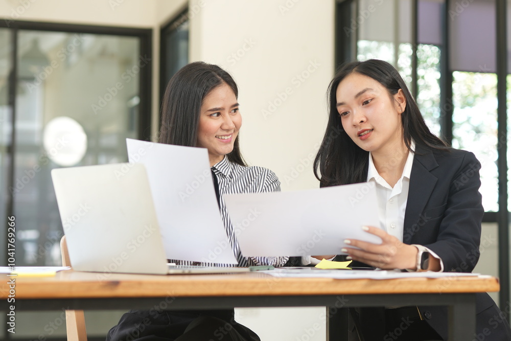 Happy Asian business people working together using laptop and tablet in office. Happy Asian business people working together using laptop and tablet in office.