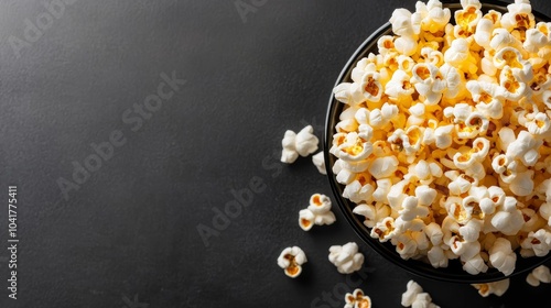 Cinematic snacking, popcorn scattered on black background for movie night indulgence