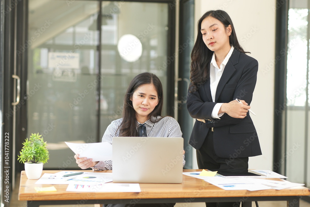 Happy Asian business people working together using laptop and tablet in office. Happy Asian business people working together using laptop and tablet in office.