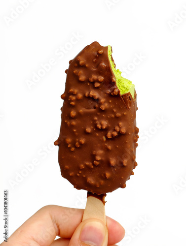 A man holding a green tea ice cream bar coated in chocolate with a bite taken out. photo