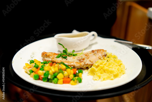 Chicken breast served with massed potato, vegetables and mushroom sauce photo