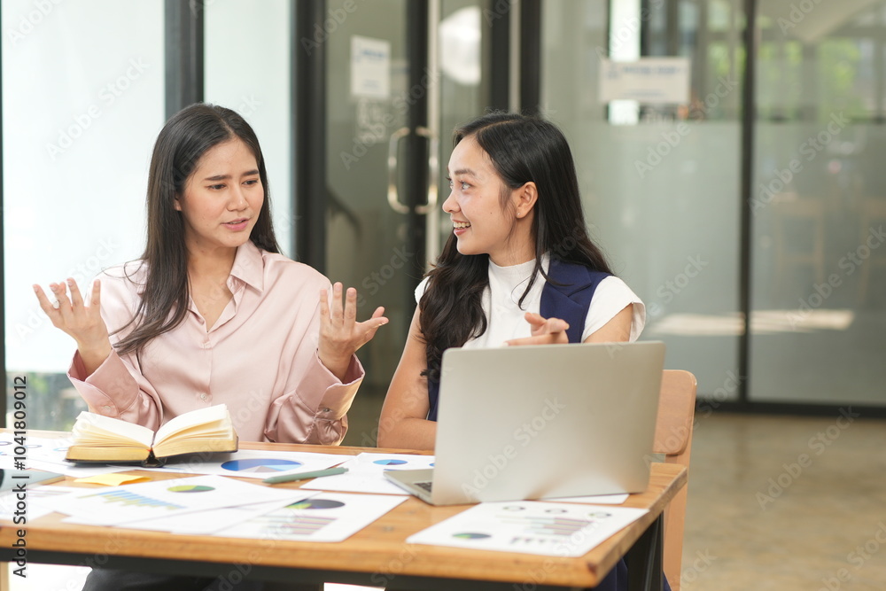 Happy Asian business people working together using laptop and tablet in office. Happy Asian business people working together using laptop and tablet in office.