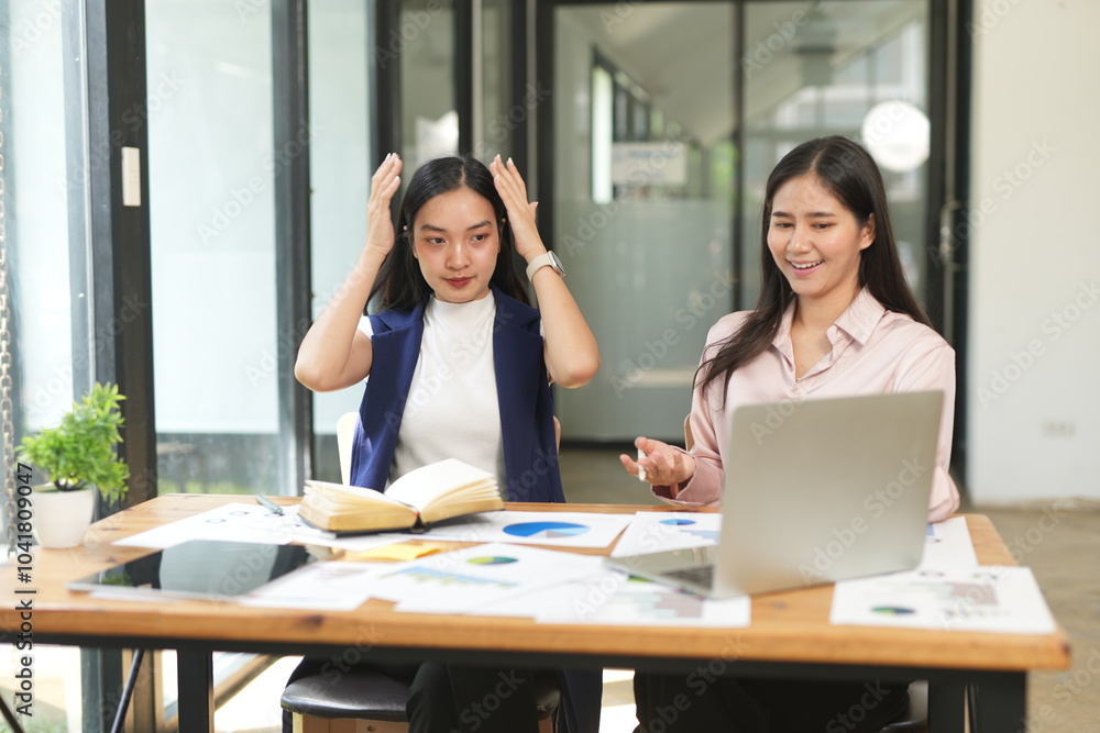 Happy Asian business people working together using laptop and tablet in office. Happy Asian business people working together using laptop and tablet in office.