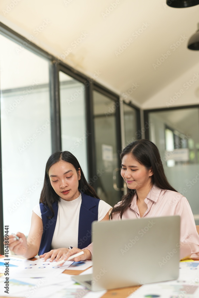 Happy Asian business people working together using laptop and tablet in office. Happy Asian business people working together using laptop and tablet in office.