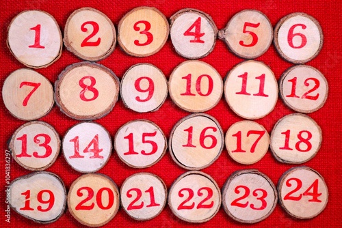 Wooden decorative 1 to 24 log button designs against a bright red stitch background. Ideal to illustrate Christmas advent countdown.