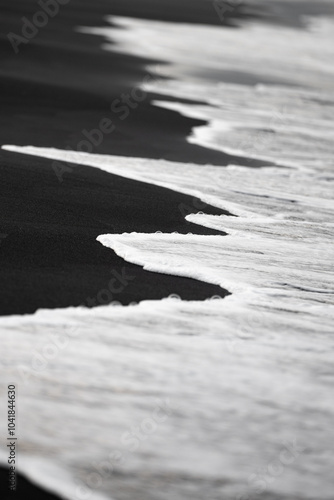 Obraz na płótnie Close-up view of some waves crashing on a black sand beach. Natural background, wallpaper. Iceland. w salonie