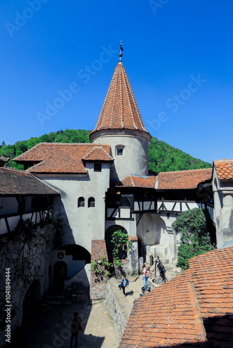 Bran Castle\'s historic architecture amidst a clear blue sky on a sunny day in Romania photo