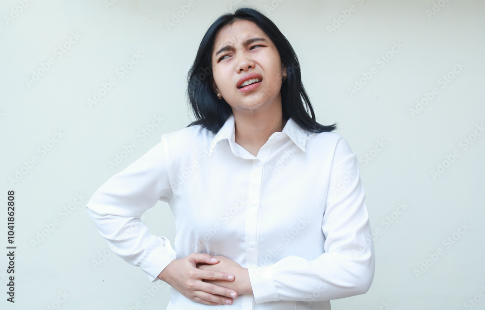 portrait of sick asian business woman secretary holding stomach feeling pain of menstruation wearing white shirt formal suit standing over isolated background portrait of sick asian business woman secretary holding stomach feeling pain of menstruation wearing white shirt formal suit standing over isolated background