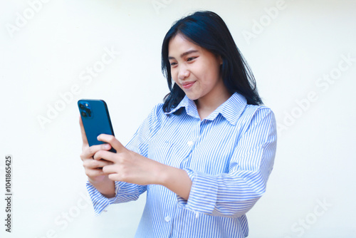 happy asian woman using smartphone surfing in social media cyberspace wearing striped shirt isolated on white background