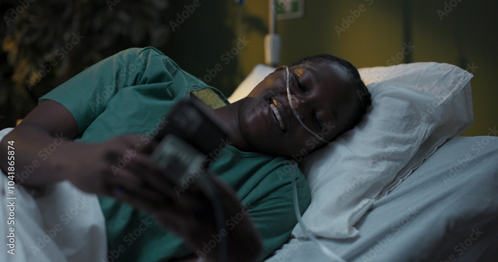 Patient with oxygen tube in hospital uses phone in hospital ward. Patient with oxygen tube in hospital uses phone in hospital ward.