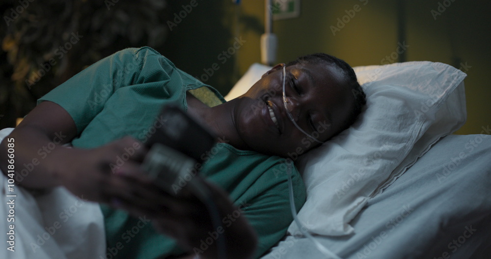 Fototapeta premium Patient with oxygen tube in hospital uses phone in hospital ward.