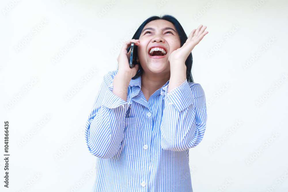 happy asian woman surprised while talking on mobile phone with raising palms wearing striped shirt isolated on white background happy asian woman surprised while talking on mobile phone with raising palms wearing striped shirt isolated on white background