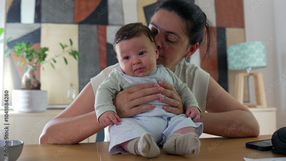 Mother smiling warmly at her baby while holding the child on a table in a cozy indoor setting. peaceful family bonding moment between a mother and her happy baby Mother smiling warmly at her baby while holding the child on a table in a cozy indoor setting. peaceful family bonding moment between a mother and her happy baby