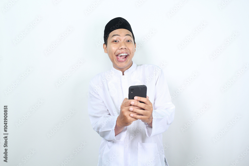 funny and amazed face of muslim asian man holding phone with looking at camera funny and amazed face of muslim asian man holding phone with looking at camera