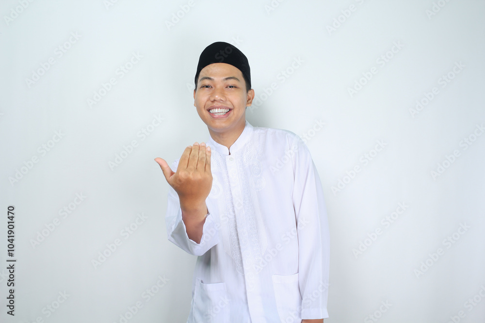 smiling muslim asian man show inviting gesture with looking at camera isolated on white background
