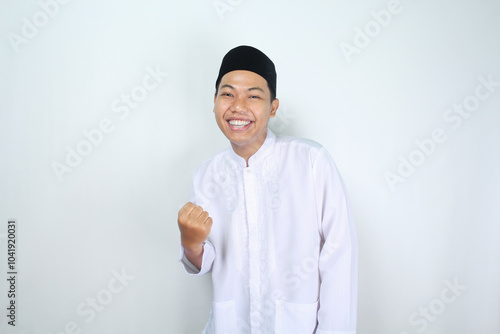 happy muslim asian man raising fist show victory gesture in eid mubarak celebration isolated on white background