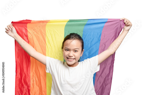 A young girl is holding a rainbow flag and smiling