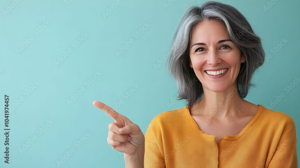 A smiling businesswoman points enthusiastically at something, showcasing a gesture of success and positivity A smiling businesswoman points enthusiastically at something, showcasing a gesture of success and positivity