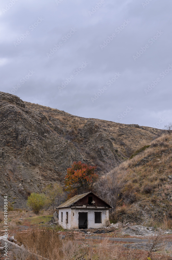 a white ruined house in the mountains against the background of an autumn tree a white ruined house in the mountains against the background of an autumn tree