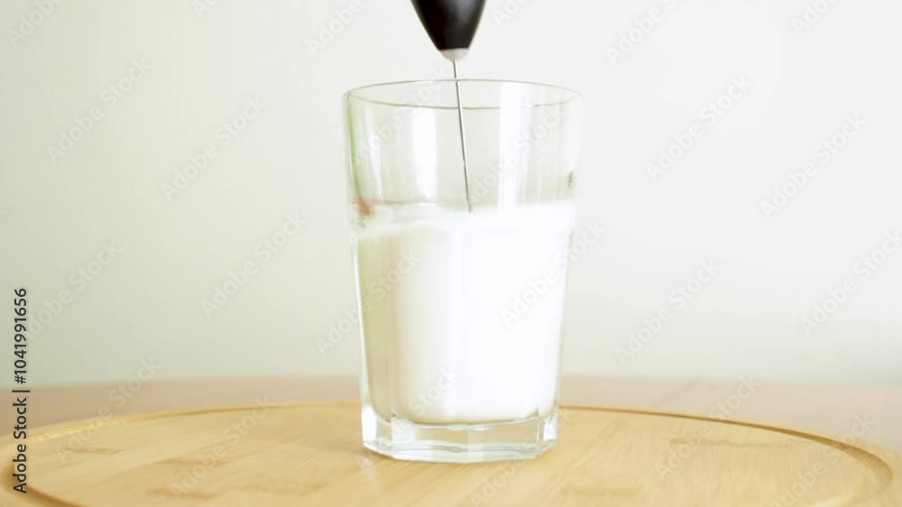 Frothing milk for coffee. Making the perfect foam with an electric milk frother.
