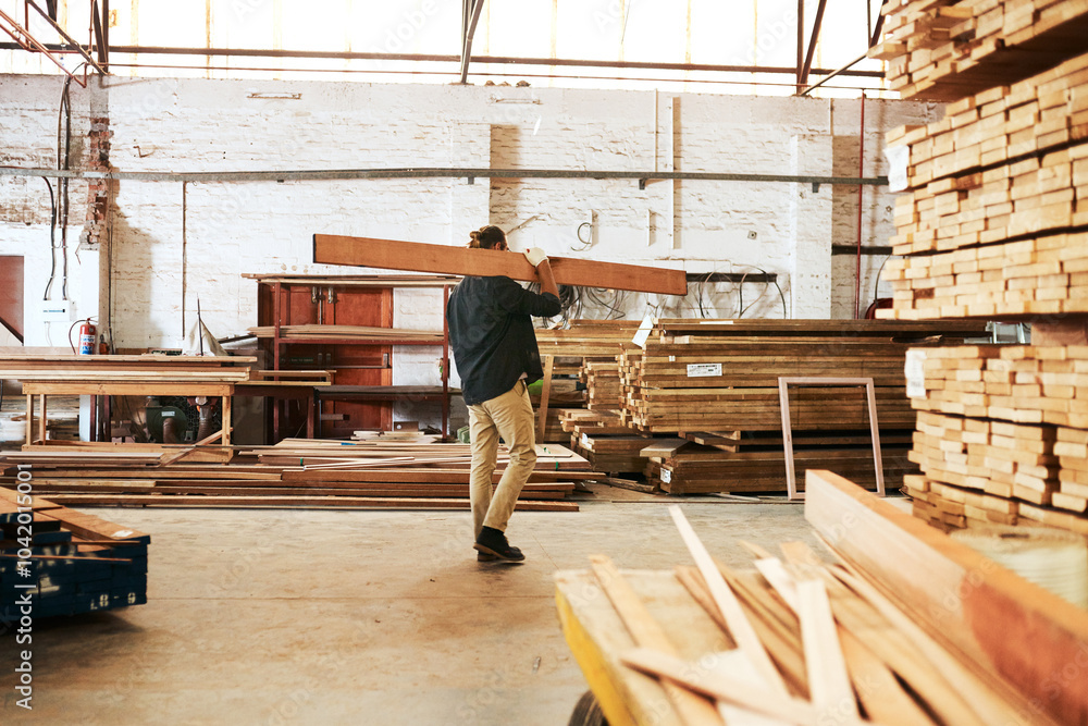 Fototapeta premium Timber, workshop and carpenter carrying wood for builder maintenance or repair project at industrial industry. Man, production and lumber for manufacturing business and woodworking trade with stack