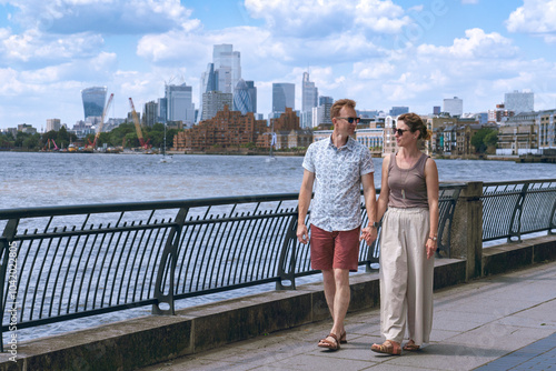 Couple walking on a river shore in London