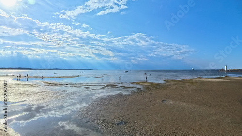 A vast sandy sea beach. Sunset over the sea. Beautiful sunny weather over the sea on a summer afternoon.