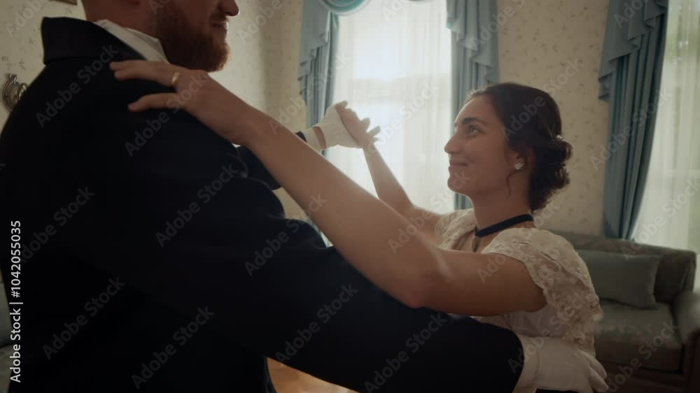 Medium slowmo shot of Victorian-era couple in formal attire looking into each other eyes while dancing in classically designed spacious salon at party Medium slowmo shot of Victorian-era couple in formal attire looking into each other eyes while dancing in classically designed spacious salon at party
