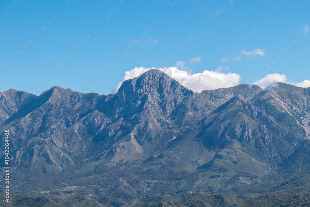 Scenic view of majestic Ceraunian mountain range in Albania, with clear blue sky above the peak. slopes are covered in lush green vegetation. Hiking and outdoor activities in Albanian Alps. Wanderlust Scenic view of majestic Ceraunian mountain range in Albania, with clear blue sky above the peak. slopes are covered in lush green vegetation. Hiking and outdoor activities in Albanian Alps. Wanderlust