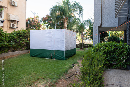 Jewish festival of Sukkot in Israel. Traditional sukkah with handmade decorations near the building on the street.  photo