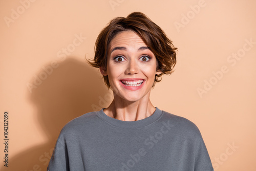 Photo portrait of lovely young lady cheerful beaming smile dressed stylish gray garment isolated on beige color background