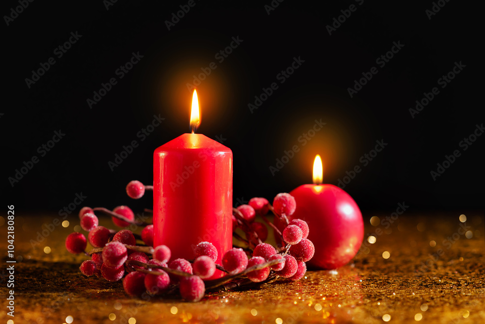Two red Christmas candles on a dark background