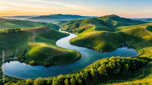 Breathtaking aerial view of rolling green hills and a winding river at sunset, perfect for nature, travel, or outdoor adventure themes