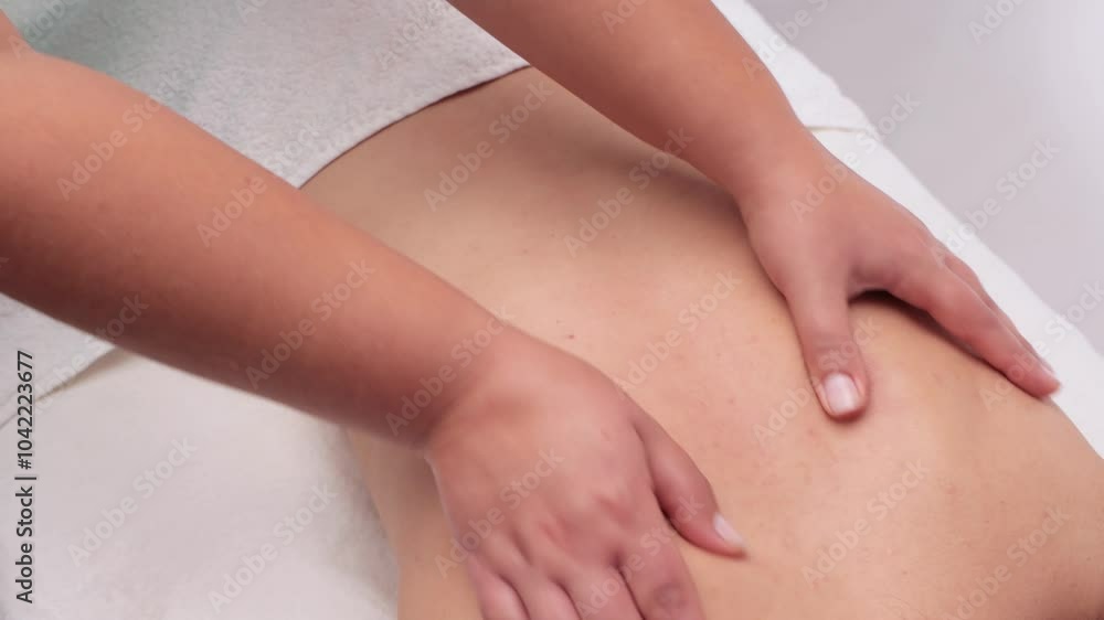 Masseur makes a relaxing massage on the neck, shoulders, back and collarbones of a young beautiful woman in a spa. Treatment for back pain.