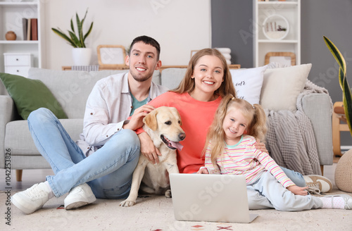 Happy family with Labrador dog and laptop at home