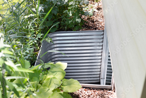 Steel window well. Egress window well installed in a basement.