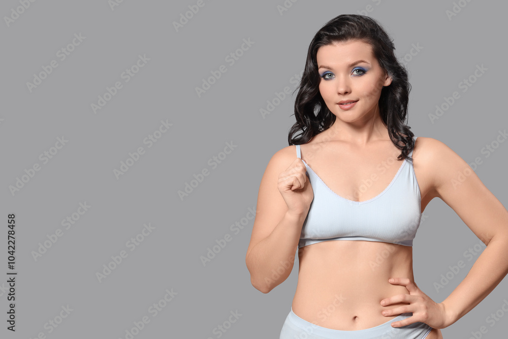 Beautiful young body positive woman in stylish underwear on grey background Beautiful young body positive woman in stylish underwear on grey background