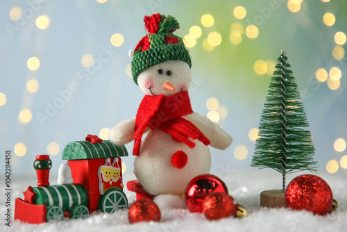 Cute decorative snowman and other Christmas decor on artificial snow photo