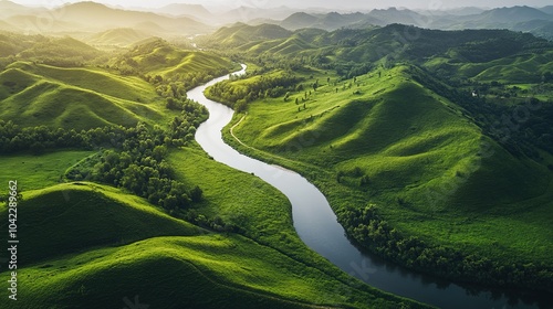 Lush green hills surround a winding river beneath a cloudy sky in a serene landscape during the early morning