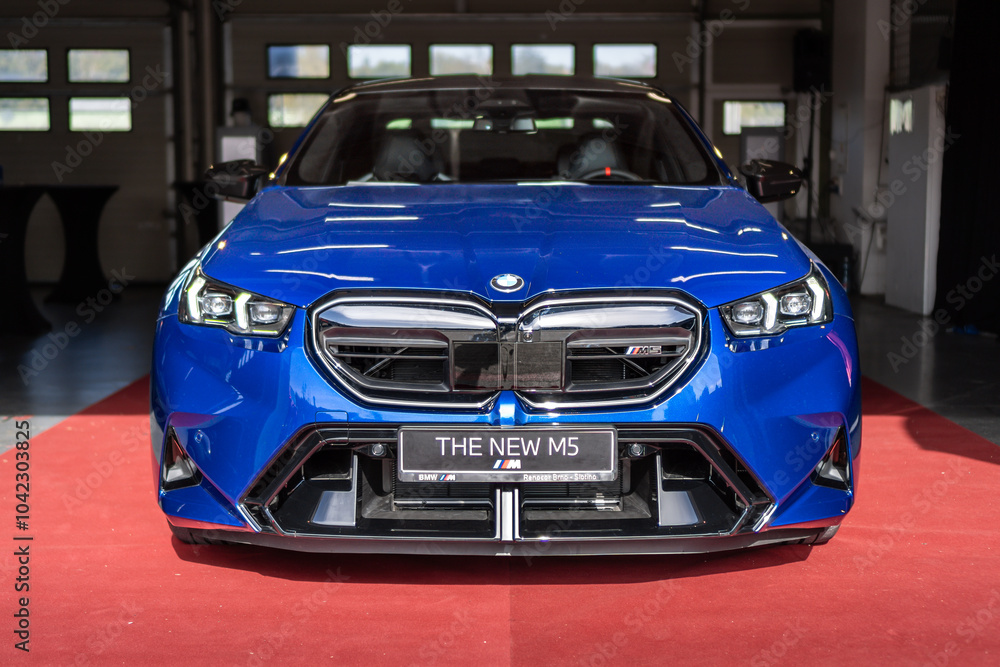 Front view of the new 2024 BMW M5 marked G90 in blue color. A luxurious ...