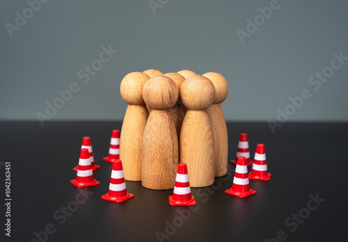 A group of people are surrounded by traffic cones. Limitations and boundaries. Rights and freedoms. Control and supervision, infringement of minorities. Safety photo