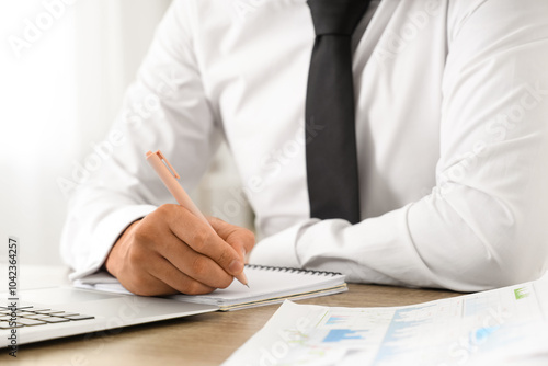 Young businessman writing o...