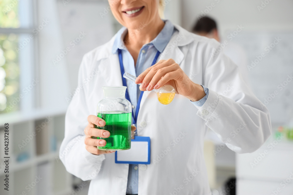 Mature female chemist with flasks in laboratory, closeup Mature female chemist with flasks in laboratory, closeup