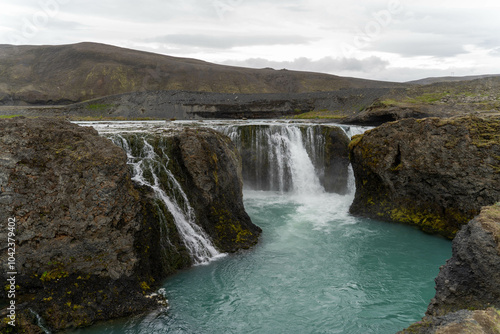 Waterfalls against a backdrop of green hills